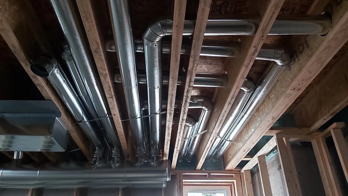 Spiral sheet metal ductwork run through floor joists by Caloris in Calgary